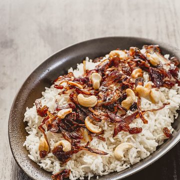 rice with fried shallots on top served in black plate