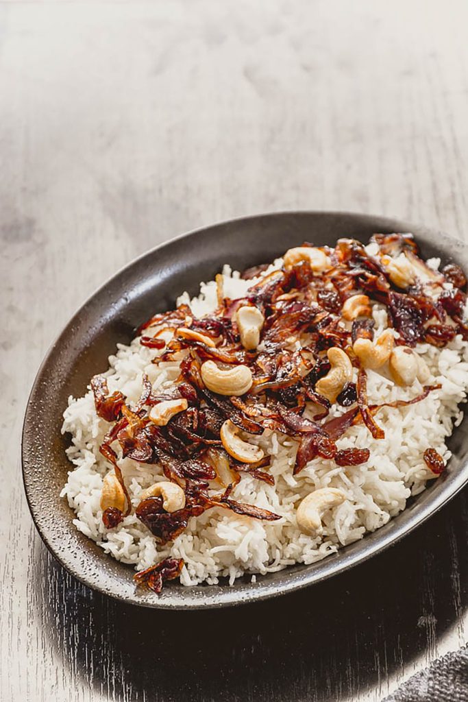 rice with fried shallots on top served in black plate