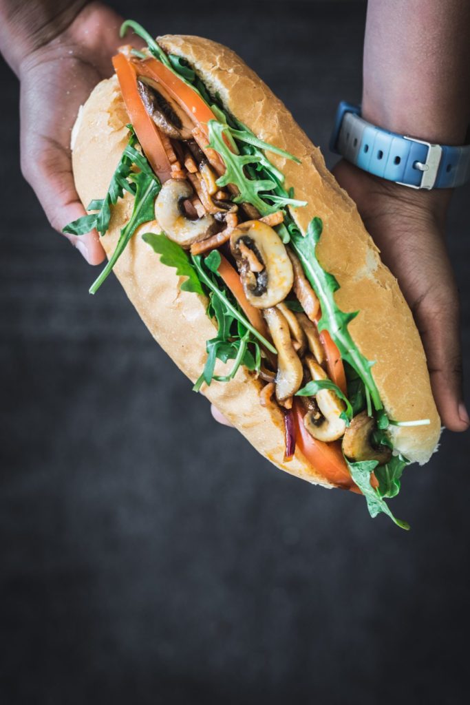 hand holding bacon mushroom sandwich