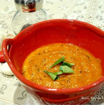 Garlic chutney garnished with curry leaves in red bowl