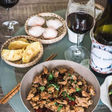 Chicken stir fry along with dumplings and red wine on lazy susan