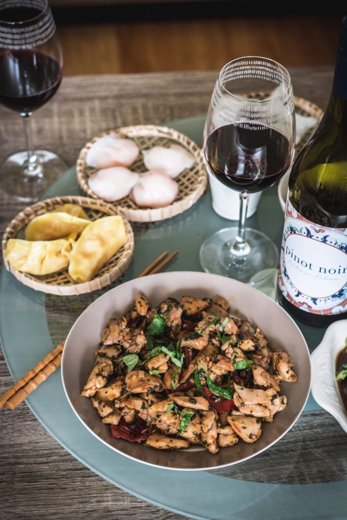 Chicken stir fry along with dumplings and red wine on lazy susan