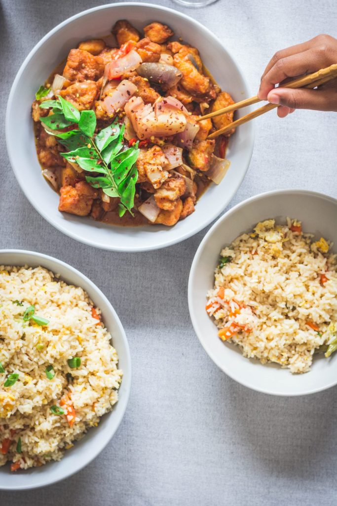 fish chilli and fried rice in white bowls