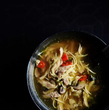 Chicken noodle soup in black bowl