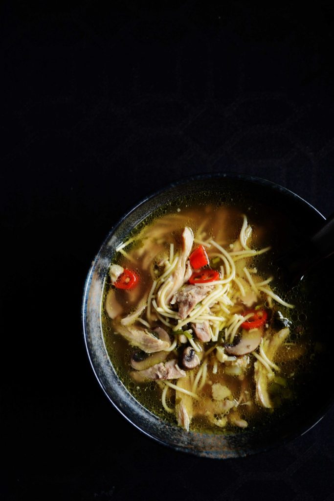 Chicken noodle soup in black bowl