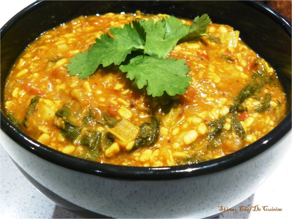 Indian lentil curry with greens in black bowl