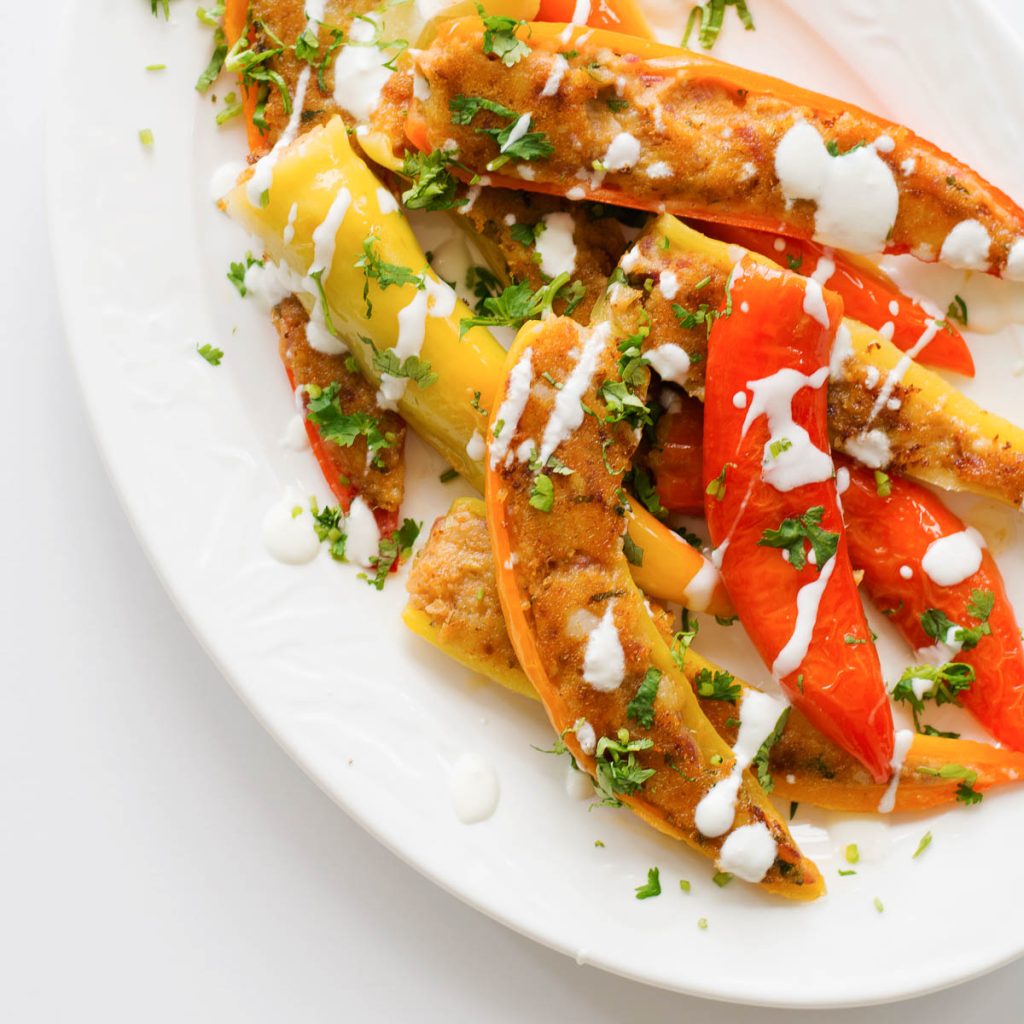 stuffed yellow and orange bullhorn chillies in a white platter