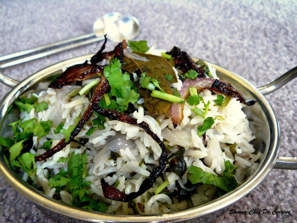 Rice dish garnished with fried onions and coriander leaves