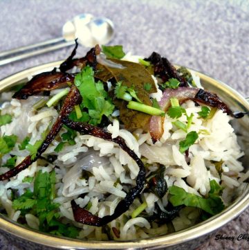 Rice dish garnished with fried onions and coriander leaves