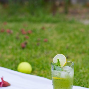 A glass of lemon mint drink placed on a book