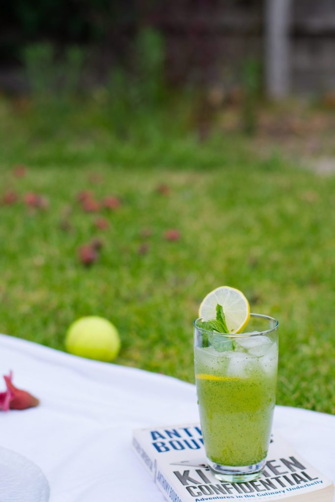 A glass of lemon mint drink placed on a book