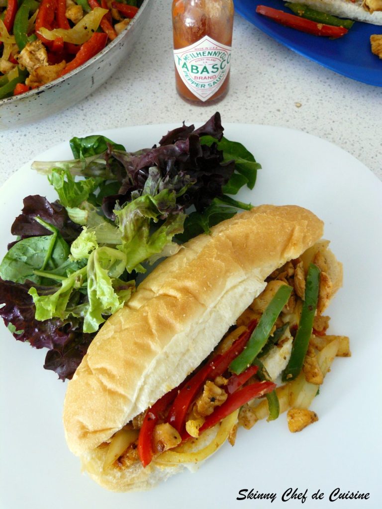 Sandwich with shredded chicken and capsicum served with a side of salad