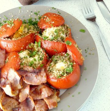 Baked eggs in tomatoes served with bacon