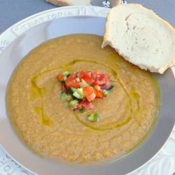 Vegetable soup in grey bowl with bread on the side