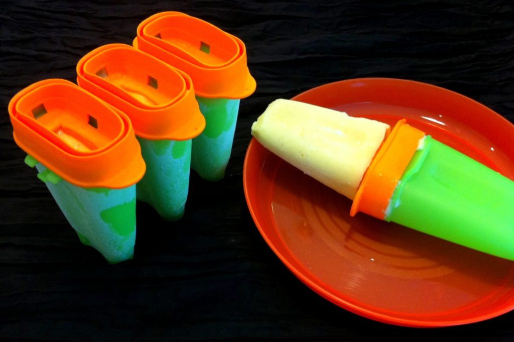 Mango popsicles in orange and green containers