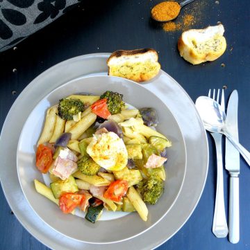 Pasta with ham, egg and vegetables served with garlic bread