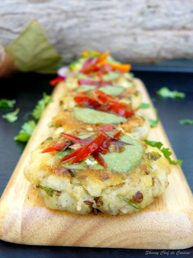 Indian style potato patties garnished with mint chutney served on wooden board