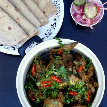 Indian chicken wings curry garnished with coriander leaves and red chillies, salad and flatbreads