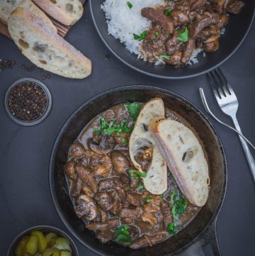 Beef stroganoff with bread in a cast iron pan and beef stroganoff served with rice in a black bowl