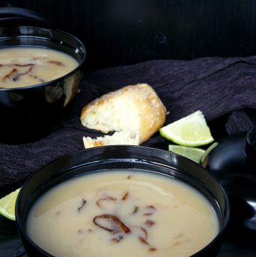 Arabian style lentil soup in black bowl with bread on the side