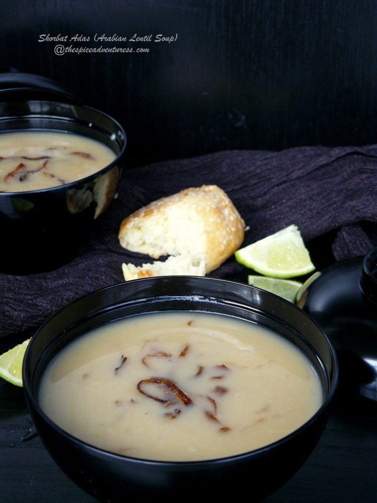 Arabian style lentil soup in black bowl with bread on the side