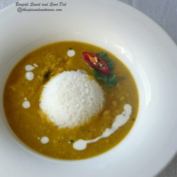 Yellow lentil curry served with rice in white bowl