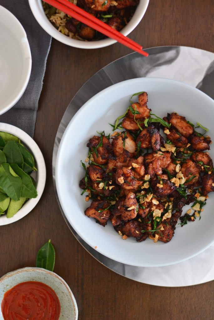 Stir fried chicken with lime leaves and garlic served in light blue bowl