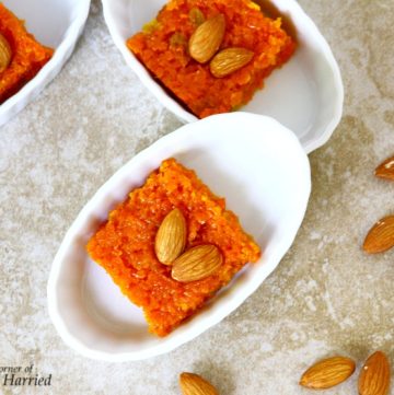 Orange coloured Indian sweet made with carrot and almonds served in small white bowl