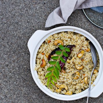 Curry leaf rice garnished with cashewnuts and fresh curry leaves served in white bowl