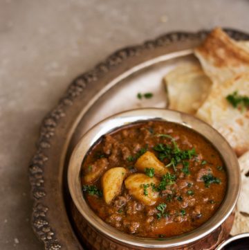 Potato and minced meat curry served in copper pot