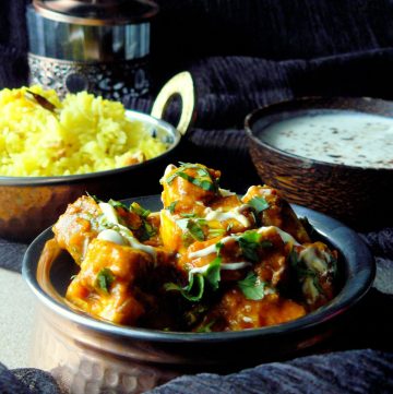 Indian cottage cheese curry in copper pot with rice on the side