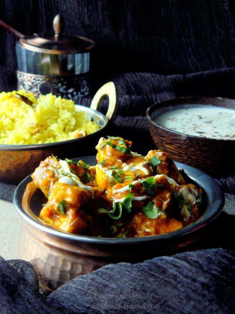 Indian cottage cheese curry in copper pot with rice on the side