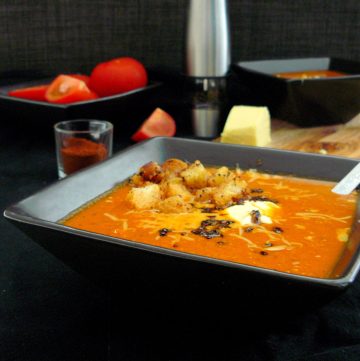 Tomato soup with croutons in black bowl