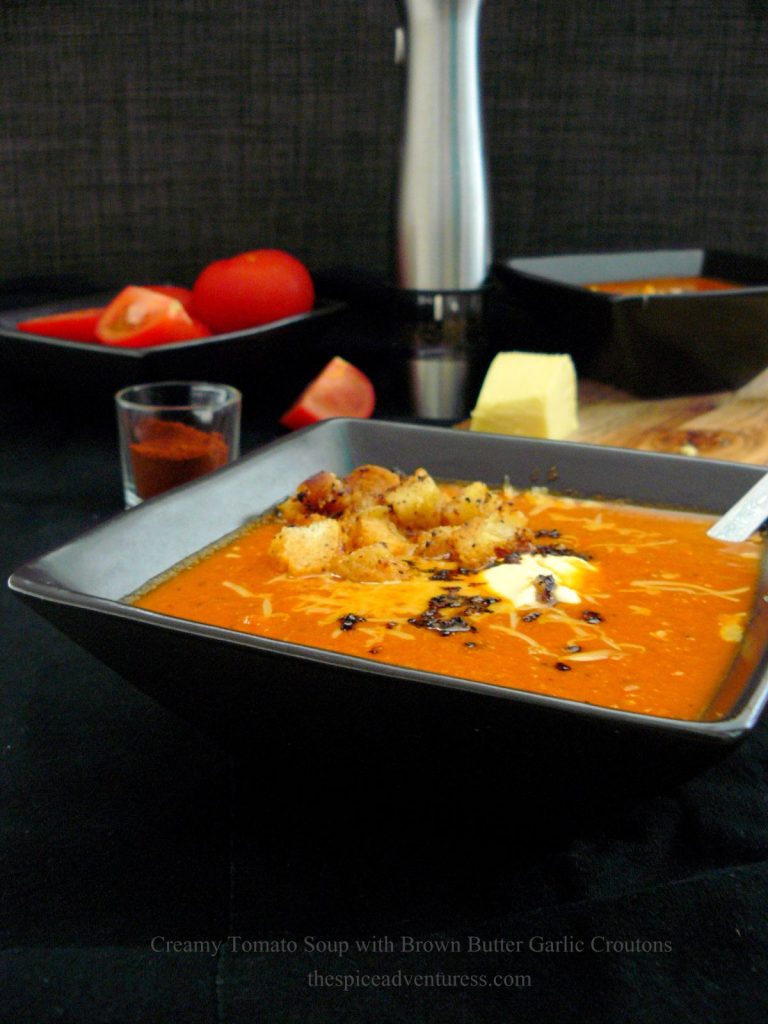 Tomato soup with croutons in black bowl