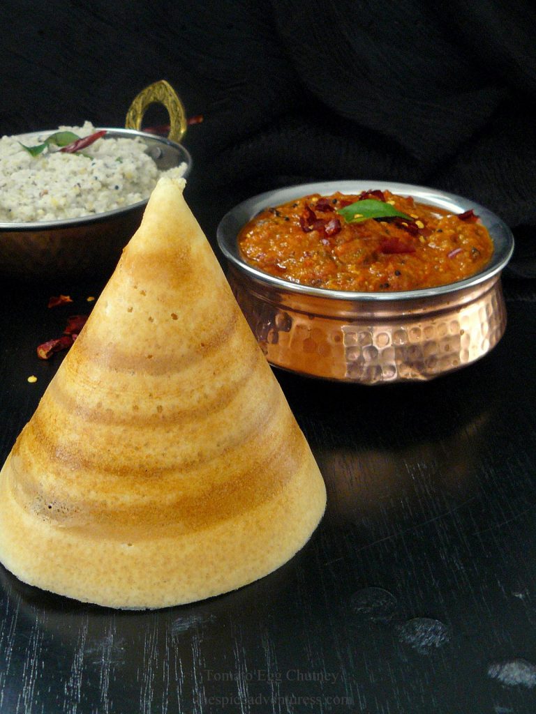 Cone shaped rice crepe and tomato egg chutney on the side