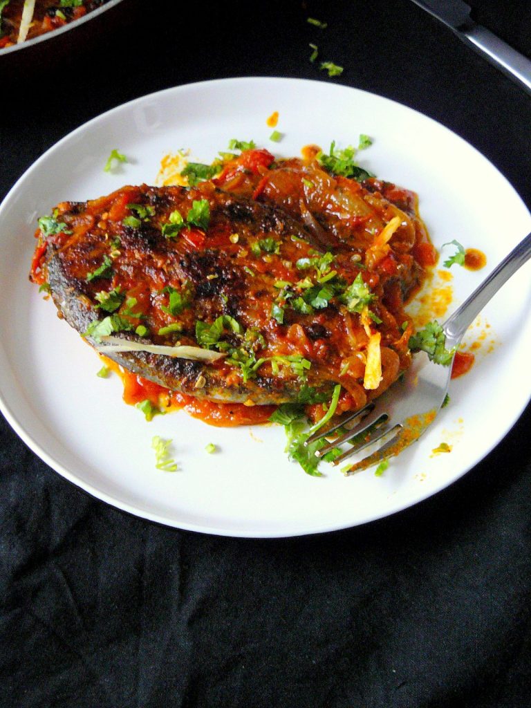 Indian fish curry served on white plate