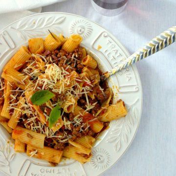 Pasta with chilli bolognese served in white plate