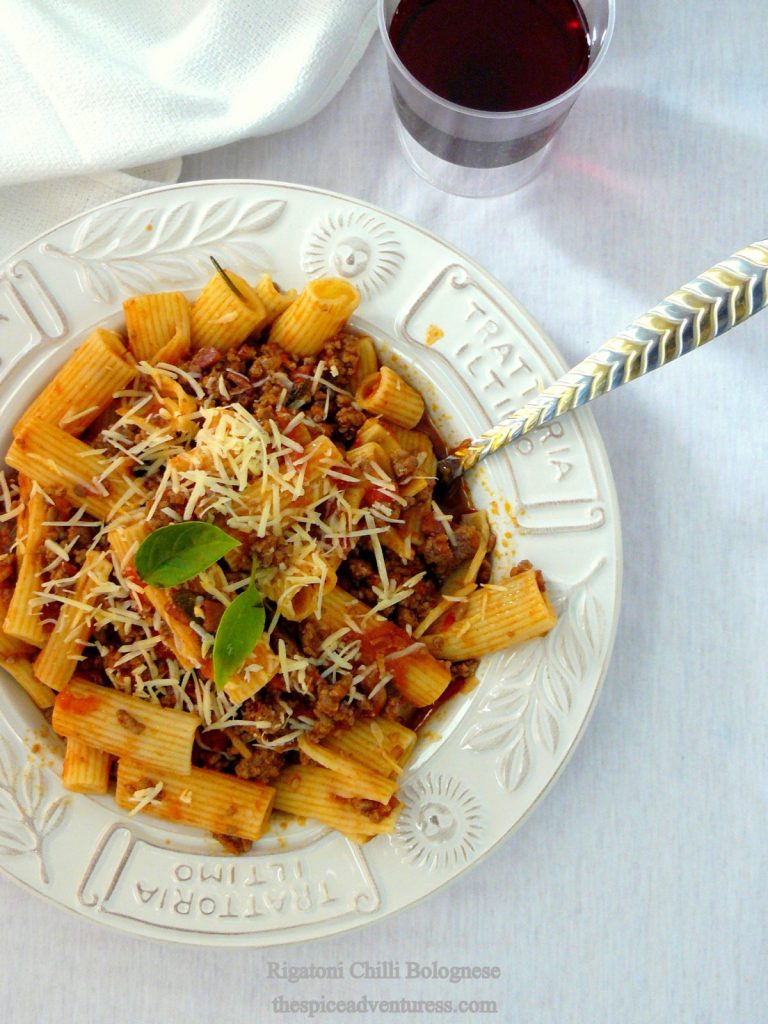 Pasta with chilli bolognese served in white plate