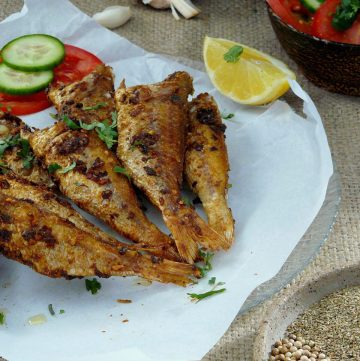 Indian fish fry with lemon, cucumber and tomato slices