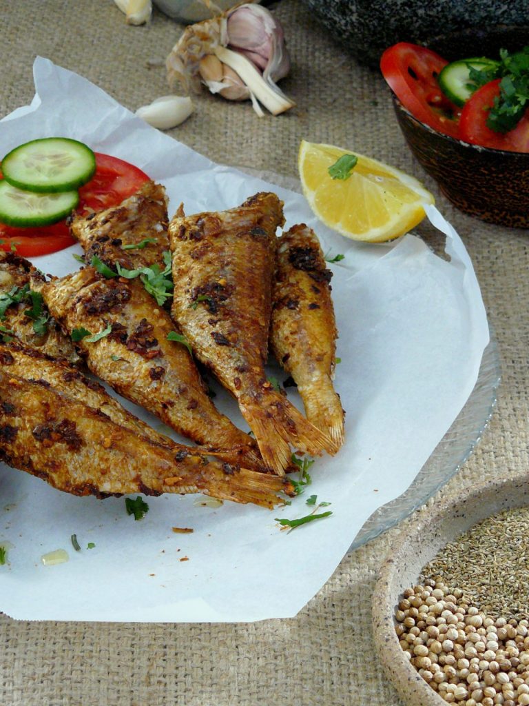 Indian fish fry with lemon, cucumber and tomato slices