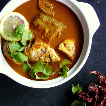 Indian style fish curry garnished with coriander leaves and lemon slice
