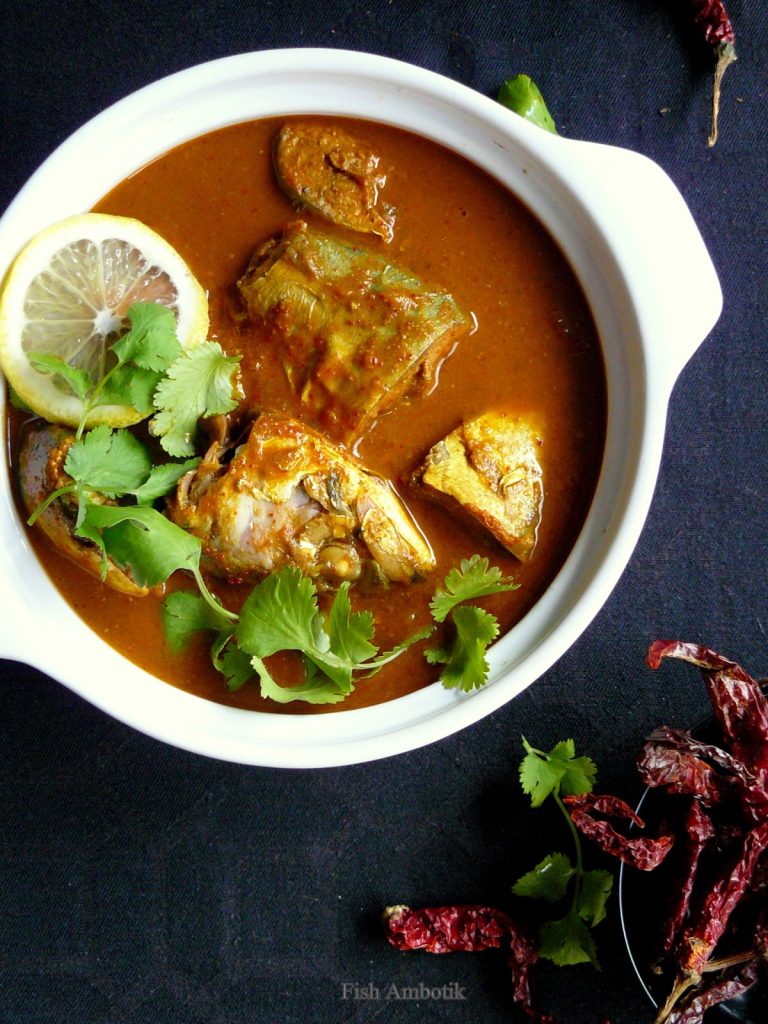 Indian style fish curry garnished with coriander leaves and lemon slice