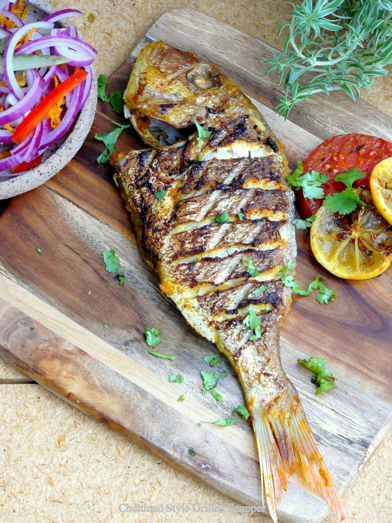 Indian style grilled whole snapper on wooden board