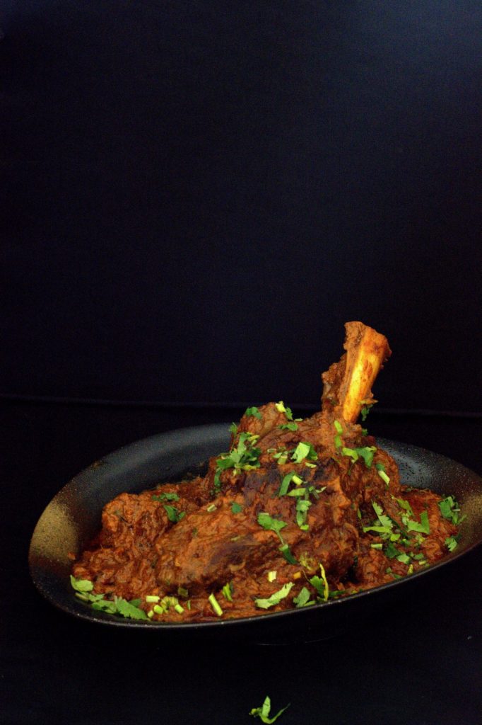 Indian lamb shanks curry served in black bowl