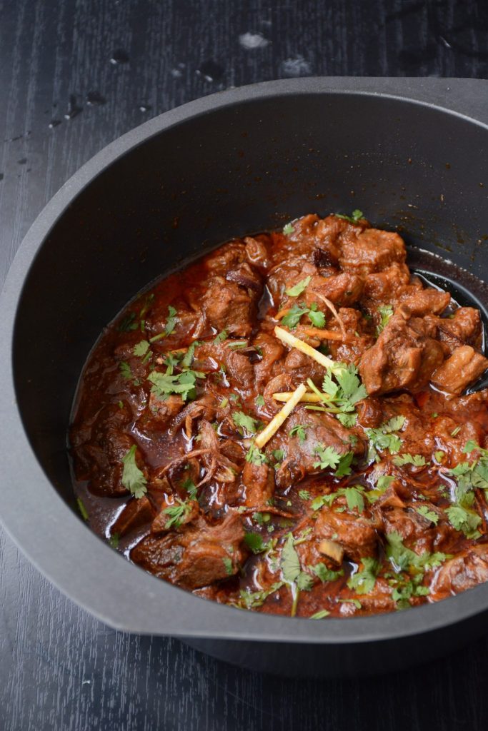 Slow cooked lamb curry in black pot