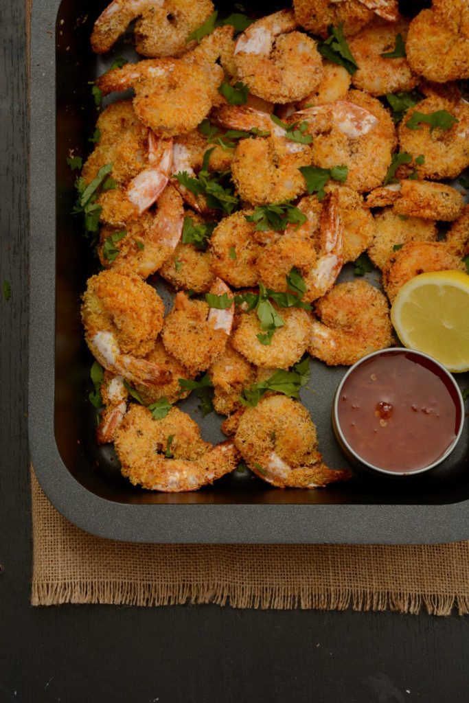 Crumbed prawns in black baking tray