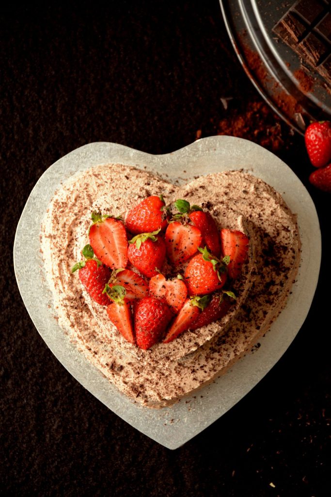 Heart shaped chocolate fudge cake with fresh strawberries on top