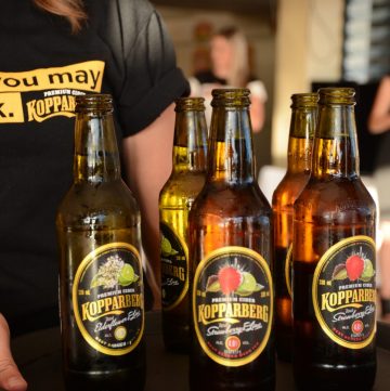 Lady carrying tray with bottles of Kopparberg cider