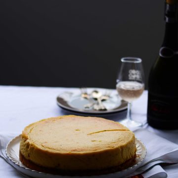 Vanilla cardamom cheesecake with a glass of wine on the side