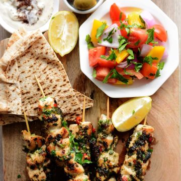 Grilled chicken skewers, pita bread, olives, fresh salad, yoghurt dip